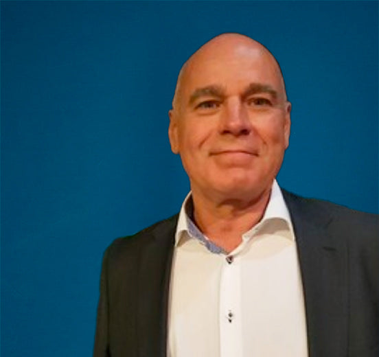 Portrait of a middle-aged man in a suit jacket and white shirt against a blue background.