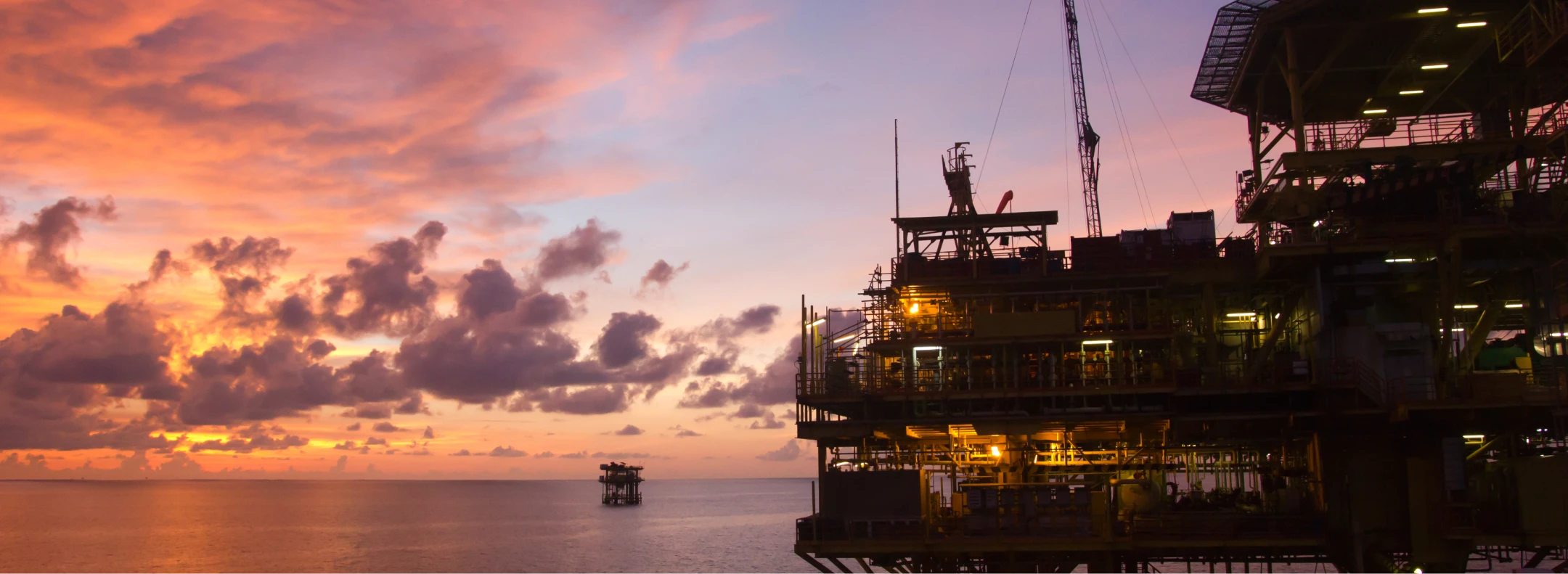 Offshore oil rig silhouette against a ripper sunset.