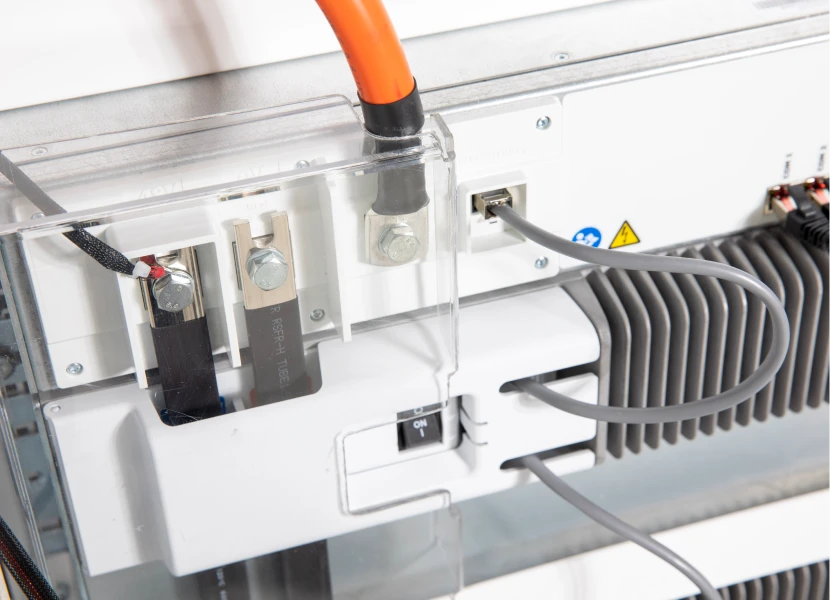 Close-up of electrical terminals, cables and an on/off switch.