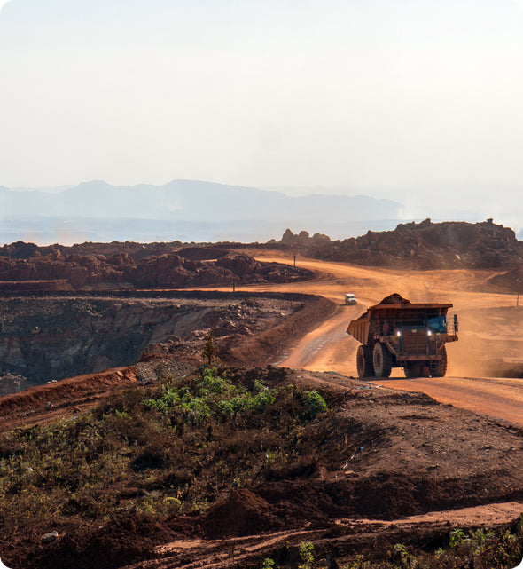 Large mining truck driving on a dirt road at an open-cut mining site