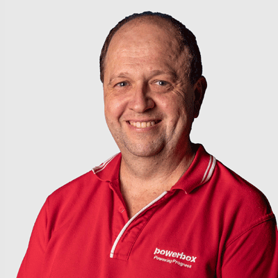 Man in red Powerbox polo shirt smiling, representing industrial power solutions expertise