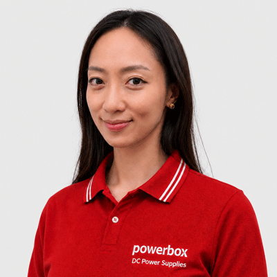 Woman in red Powerbox polo shirt with 'DC Power Supplies' text, representing industrial power solutions