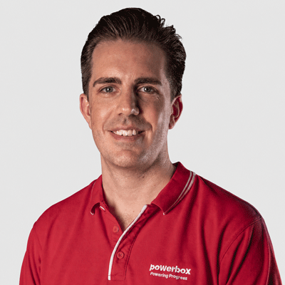 Man in red Powerbox polo shirt, smiling for professional headshot