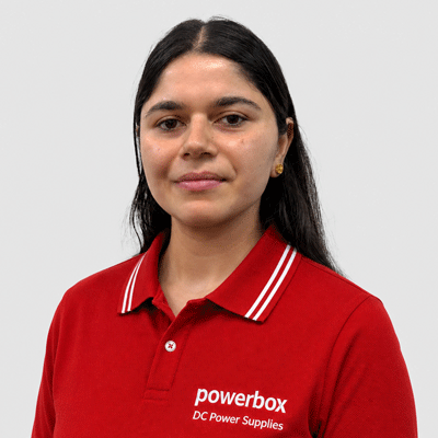 Woman in red Powerbox polo shirt with 'DC Power Supplies' text, representing industrial power solutions.