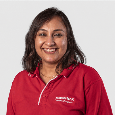 Woman in red Powerbox polo shirt smiling, representing industrial power solutions team