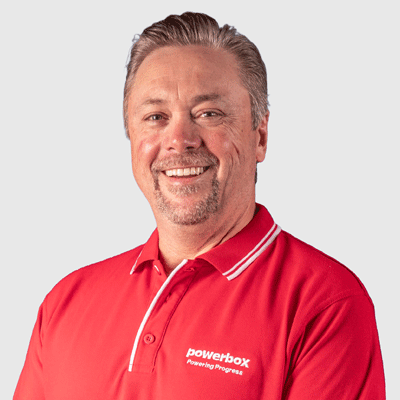 Man in red Powerbox polo shirt smiling, representing industrial power solutions and energy storage expertise