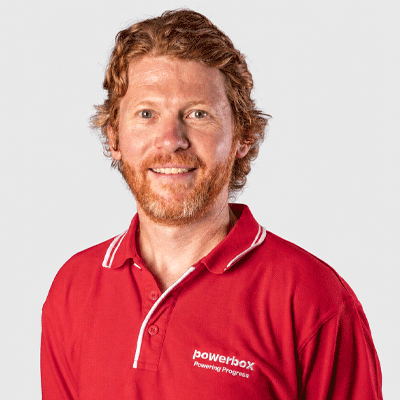 Man in red Powerbox polo shirt smiling, representing industrial power solutions expertise